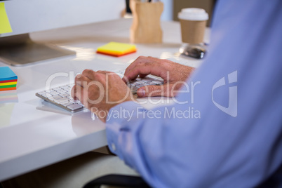 Businessman typing on keyboard in office