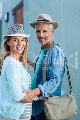 Portrait of smiling mature couple by building