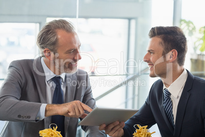 Businessmen using digital tablet in restaurant