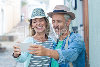 Mature couple taking selfie in city