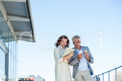 Happy couple using digital tablet and mobile phone