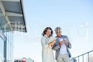 Happy couple using digital tablet and mobile phone