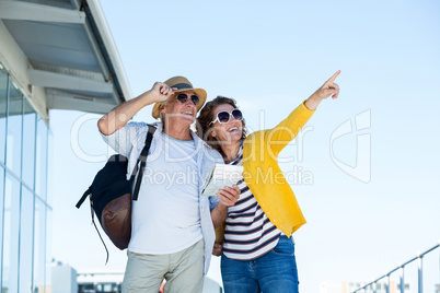 Happy couple with sunglasses standing against clear sky
