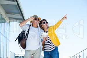Happy couple with sunglasses standing against clear sky