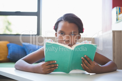 Schoolgirl reading book in library