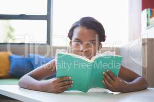 Schoolgirl reading book in library