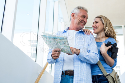 Smiling mature couple holding map