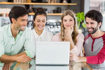 Group of happy friends using laptop