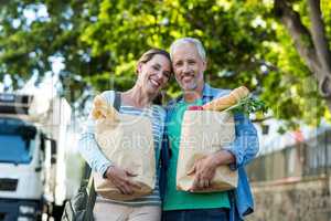 Couple holding shopping by tree