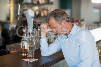 Tired man leaning his elbow on the counter