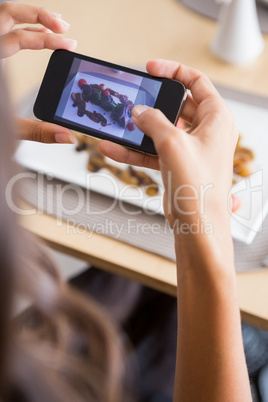 Woman taking photograph of meal