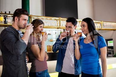 Friends drinking beer by bar counter