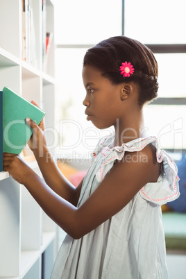 Girl taking a book from bookshelf in library