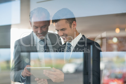 Two businessmen using digital tablet