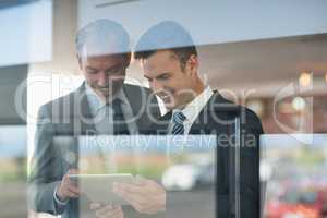 Two businessmen using digital tablet