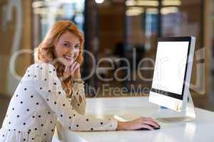 Portrait of woman using computer in office