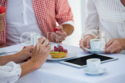 Cropped image of friends at table in restaurant