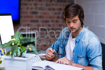 Businessman reading book at desk