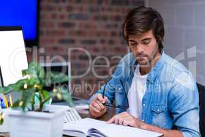 Businessman reading book at desk