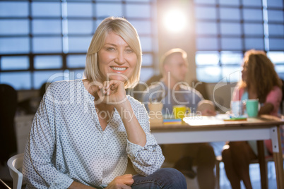 Creative businesswoman with hand on chin in office