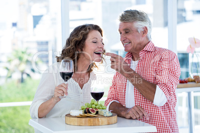 Mature man feeding food to woman