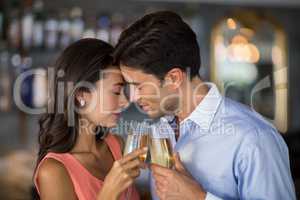 Young couple embracing while toasting a glasses of champagne