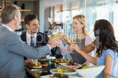 Business colleagues toasting beer glasses while having lunch