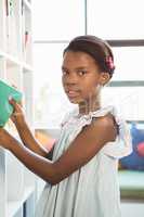 Girl taking a book from bookshelf in library