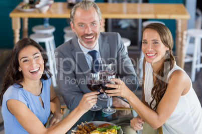 Businessman and colleague toasting glasses of wine in restaurant