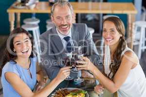 Businessman and colleague toasting glasses of wine in restaurant