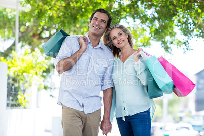 Couple with shopping bags standing on street