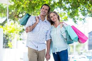 Couple with shopping bags standing on street