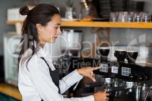 Smiling waitress making cup of coffee