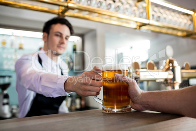 Barkeeper serving beer to customer