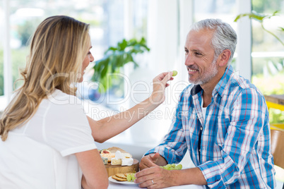 Woman feeding grapes to husband