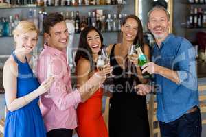 Group of friends holding glass of champagne flute and bottle