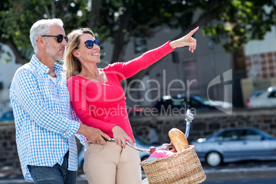Mature man with woman pointing in city