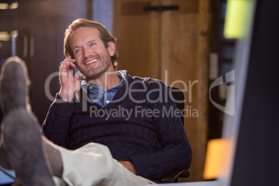 Businessman smiling while talking on cellphone Businessman smiling while talking on cellphone