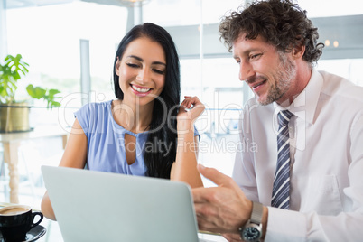 Businessman discussing with colleague over laptop