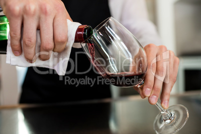 Barkeeper pouring wine in glass