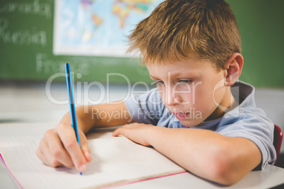 Schoolboy doing homework in classroom