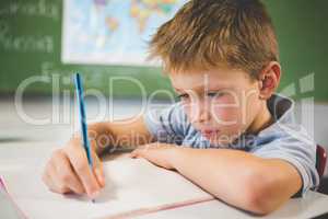 Schoolboy doing homework in classroom