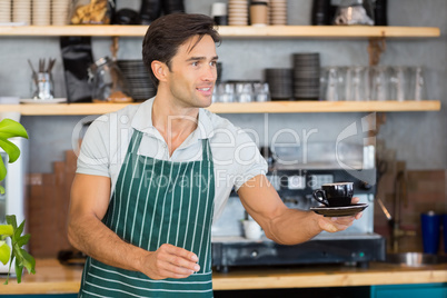 Waiter offering a cup of coffee