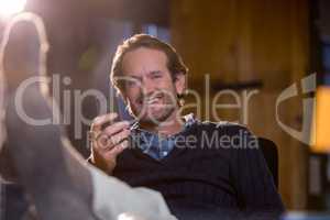 Smiling businessman holding cellphone in office