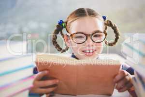 Close-up of schoolkid reading book in classroom