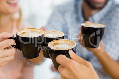 Group of happy friends toasting cup of coffee