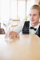 Waiter sitting at table looking at empty glass