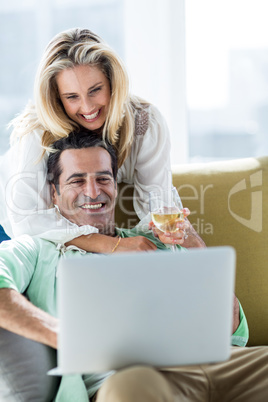 Romantic couple using laptop at home