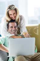Romantic couple using laptop at home
