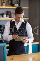 Waiter using digital tablet in restaurant
